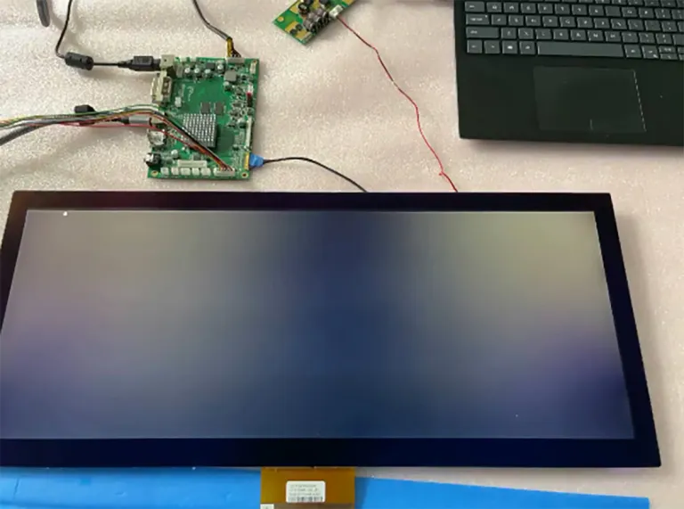 Display panel connected to controller electronics and a laptop on a test bench