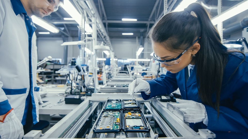Technicians handling electronic assemblies with gloves and precision tools